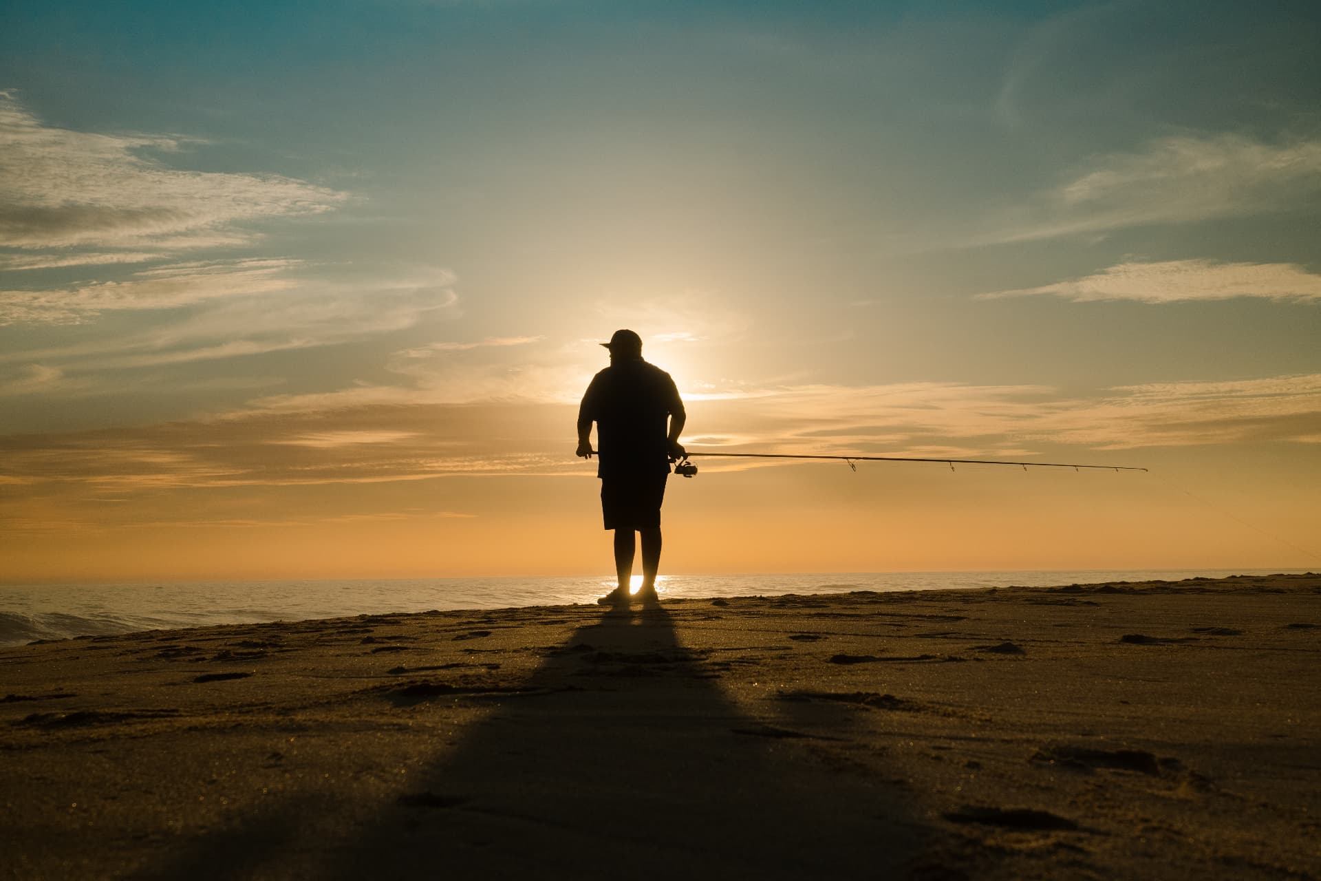 Pescador de orilla con su caña al atardecer frente al mar en México