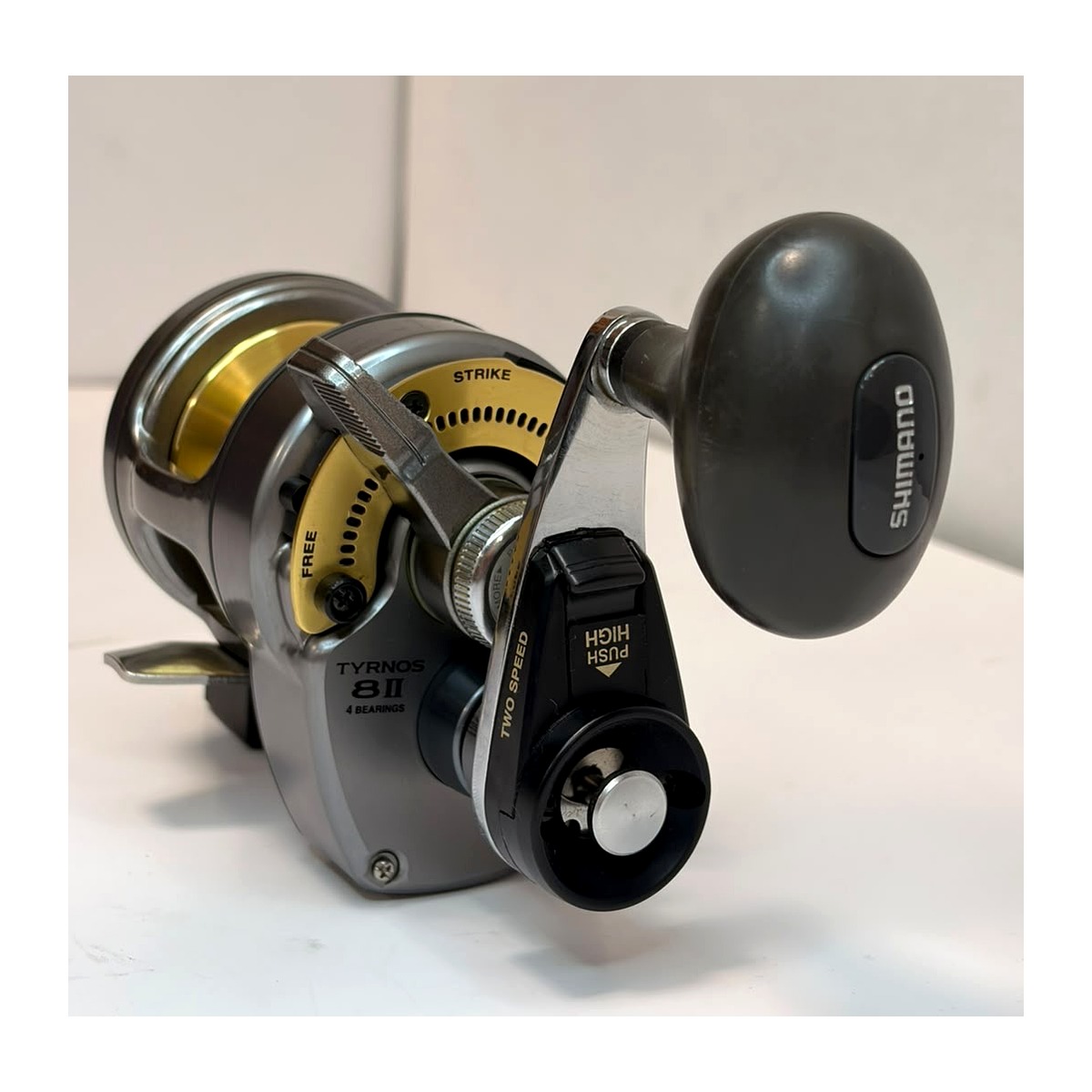 Carrete Shimano Tyrnos 8II de dos velocidades, cuerpo gris y dorado